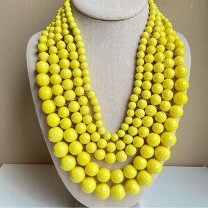 Bright yellow five layer beaded necklace with graduated faceted acrylic beads